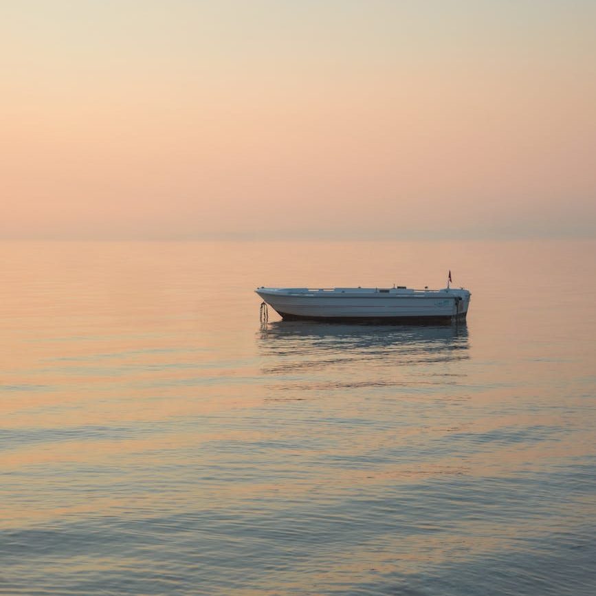 tranquil boat at sunset on calm sea